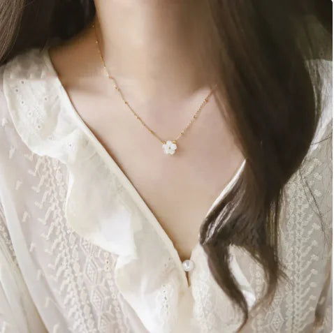 Bloom Charm Necklace worn with a white blouse, featuring a delicate floral pendant design.
