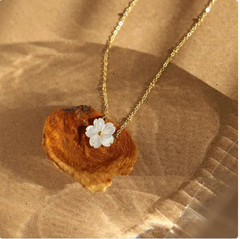 Bloom Charm Necklace featuring an elegant floral pendant on a gold chain, beautifully displayed on natural background.