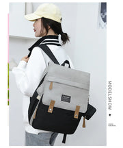 Mommy backpack in gray and black, stylish design, worn by a woman in casual attire, perfect for moms on the go.